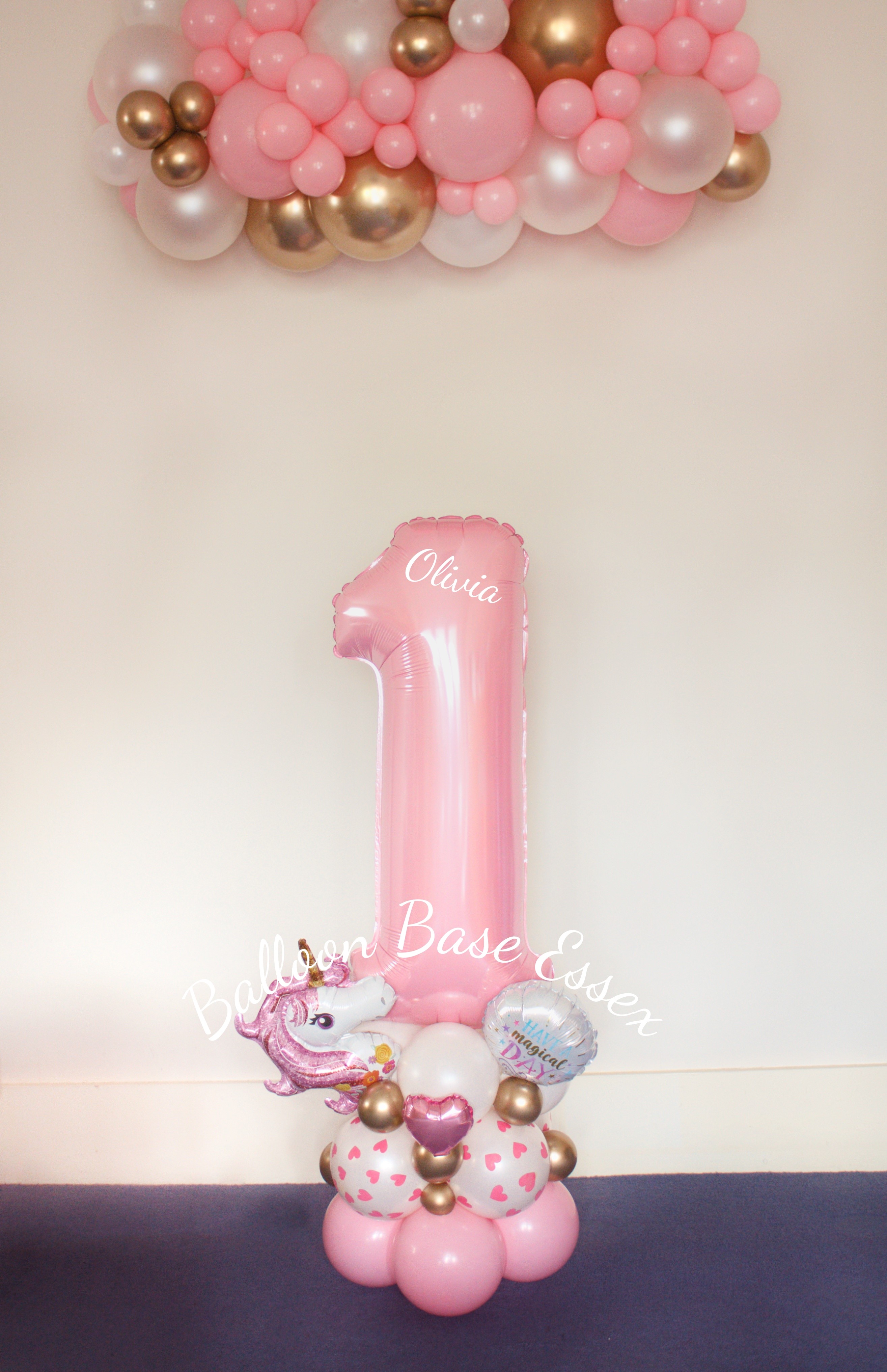 Pink luxe number 1 balloon stack with matching pink, white and gold garland hanging above