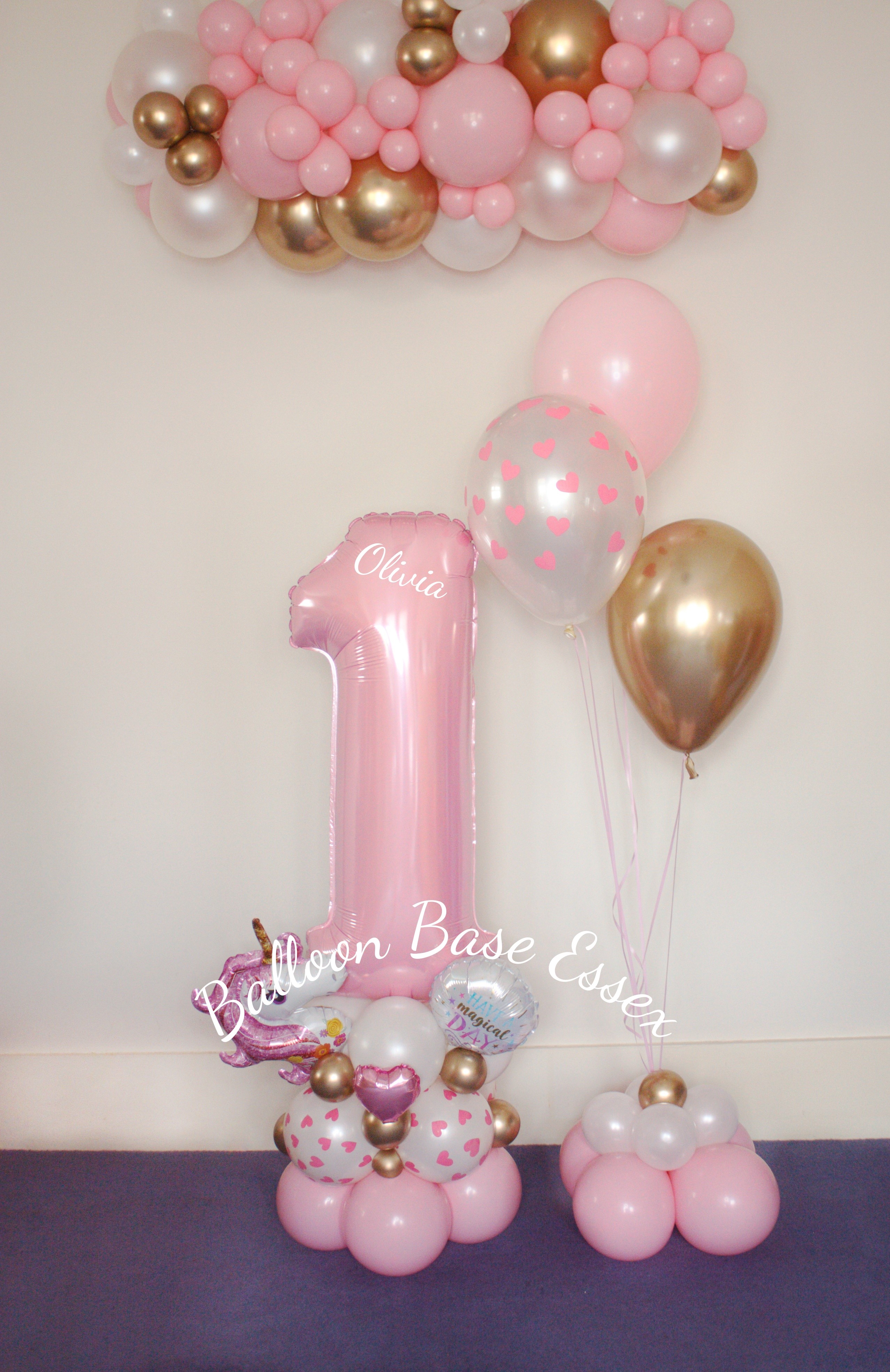 Pastel pink number 1 balloon stack with 3 helium balloons and balloon garland hanging above