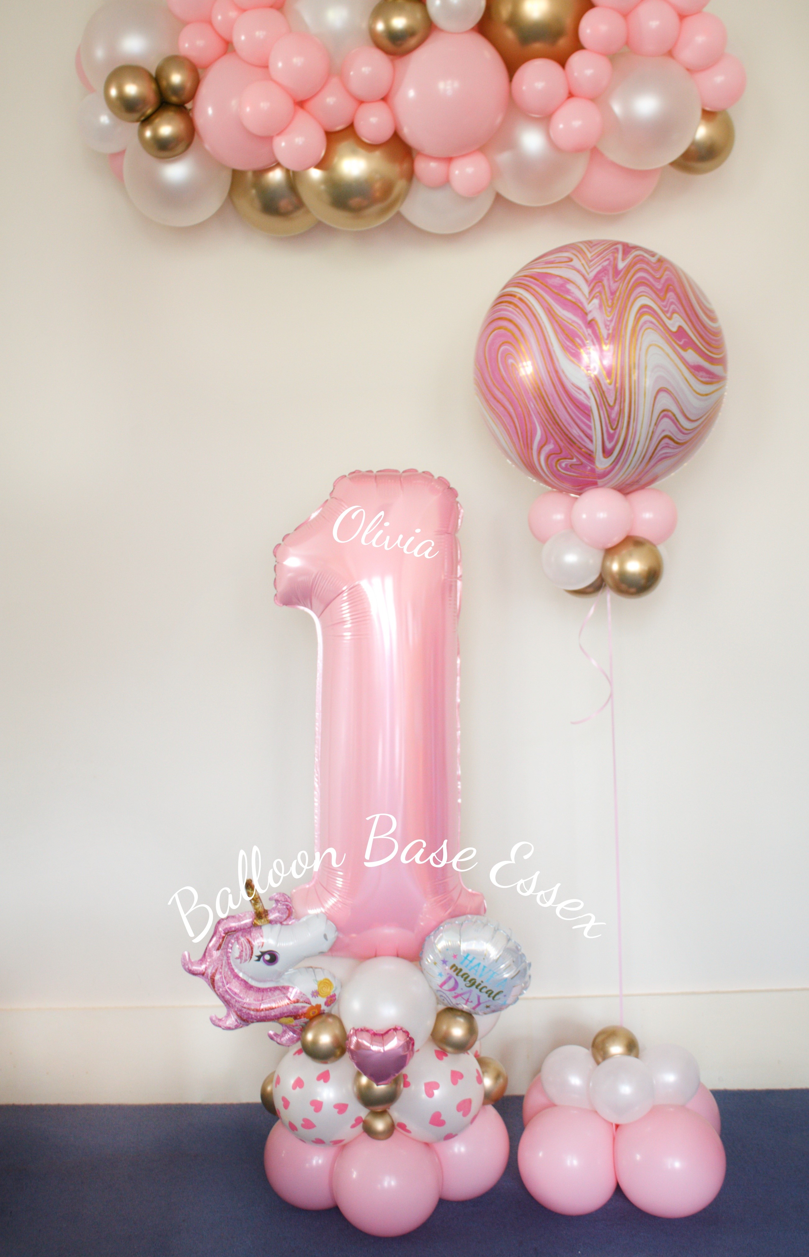 Pale pink number 1 balloon stack with pinke, white and gold marble orbz balloon and garland hanging above