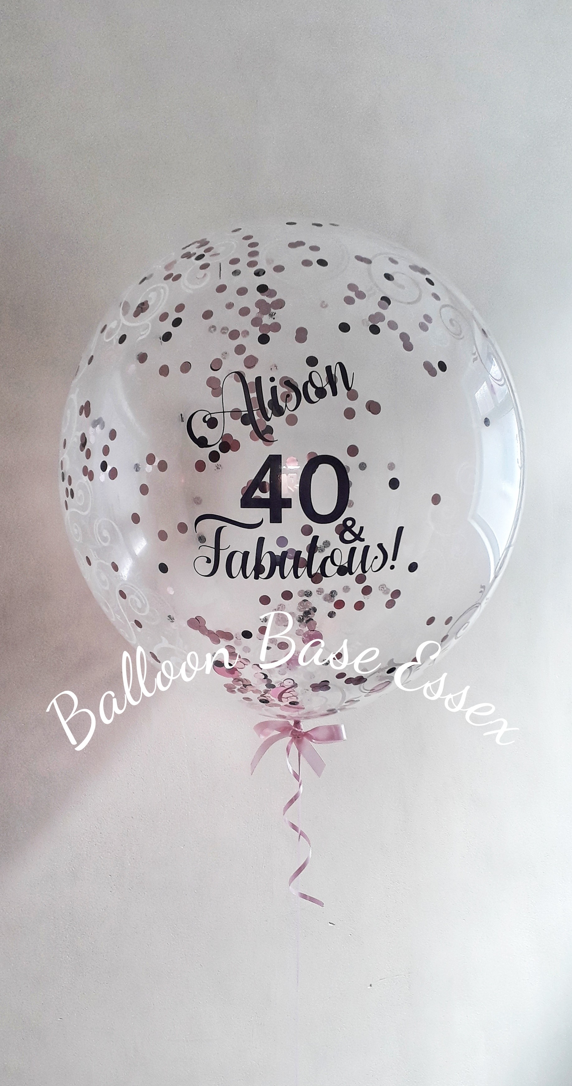 Clear bubble balloon with pink black and white confetti inside