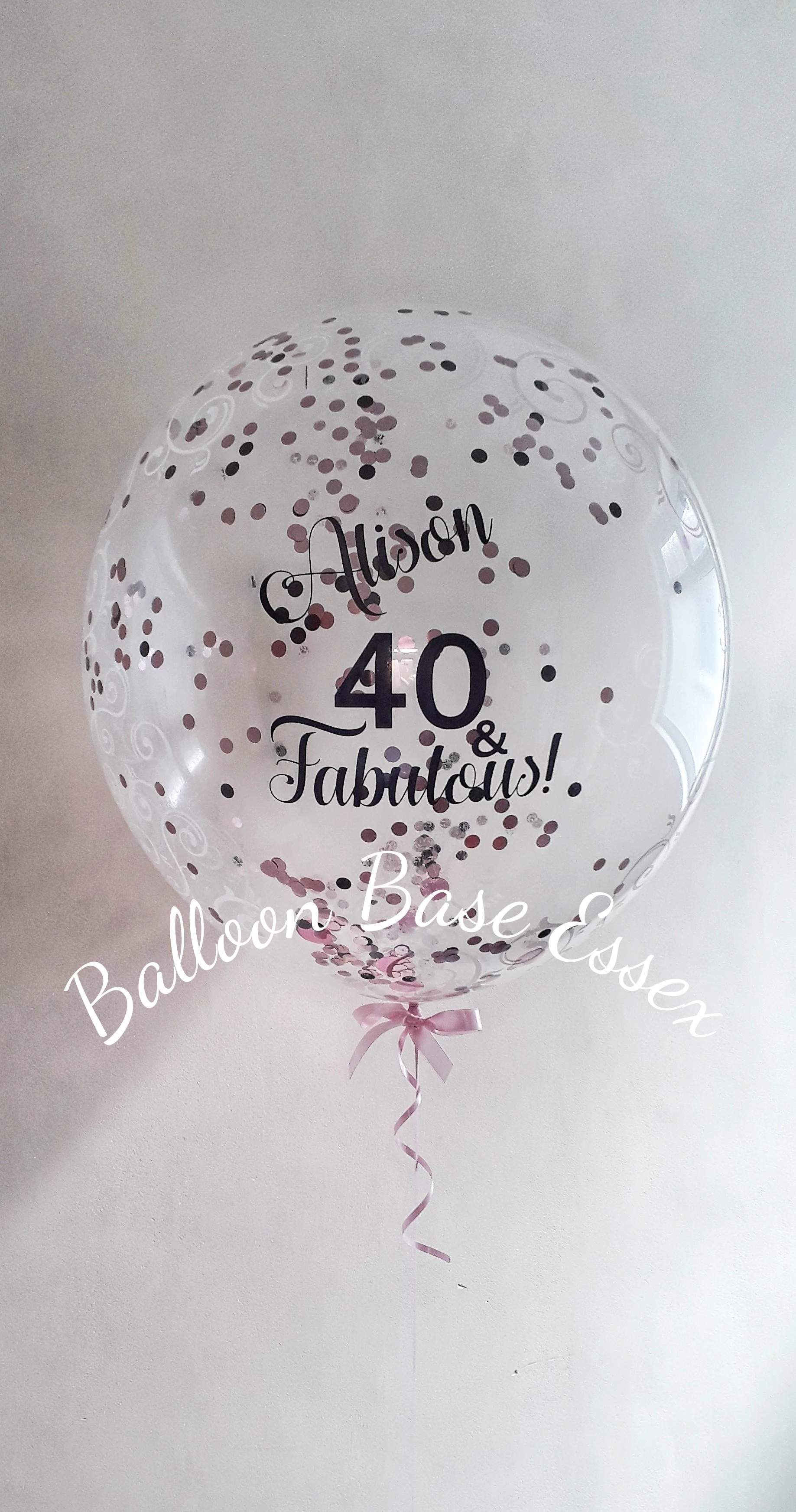 Clear bubble balloon with pink black and white confetti inside