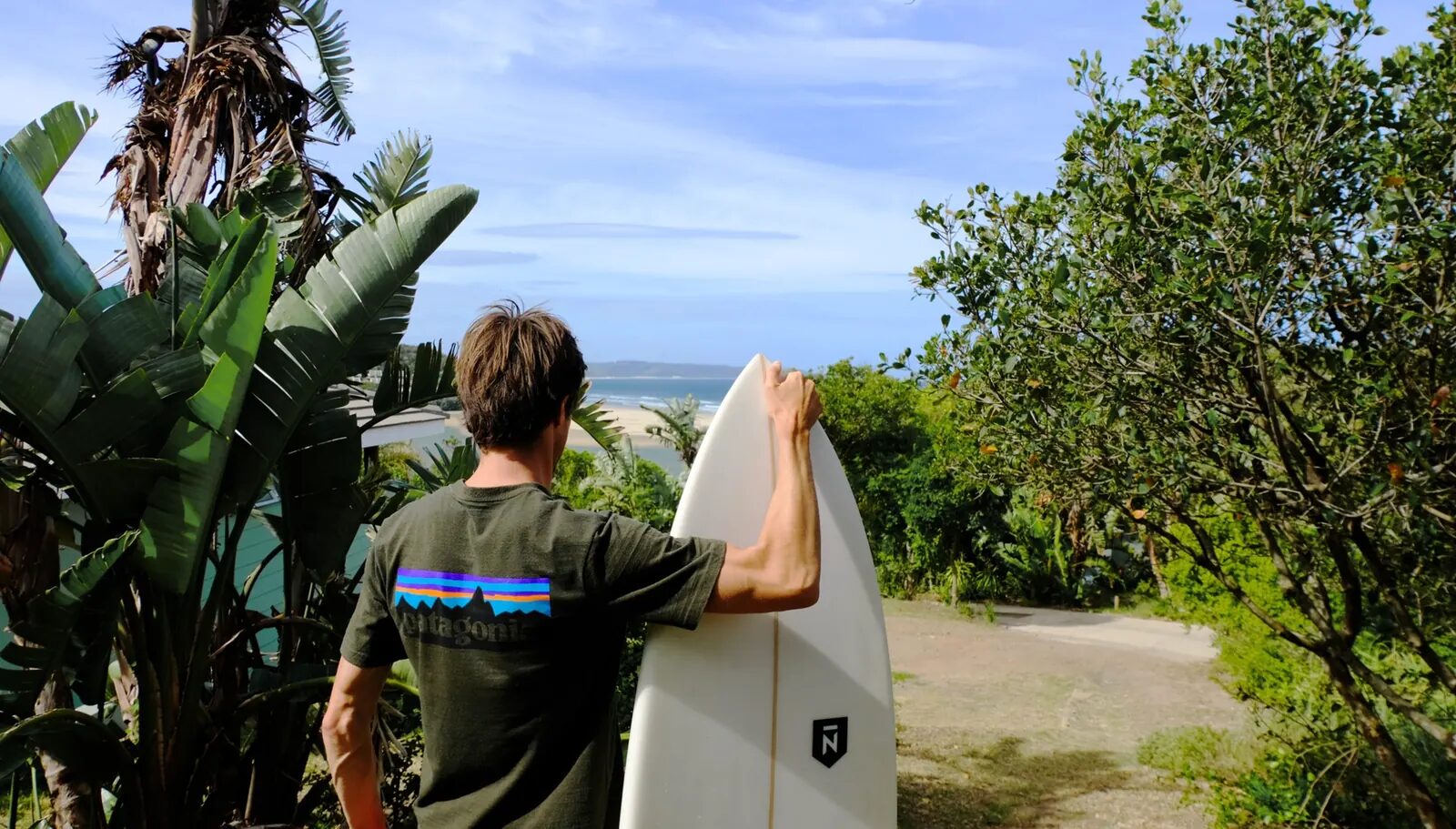 Surfer carrying a board towards Chintsa Beach