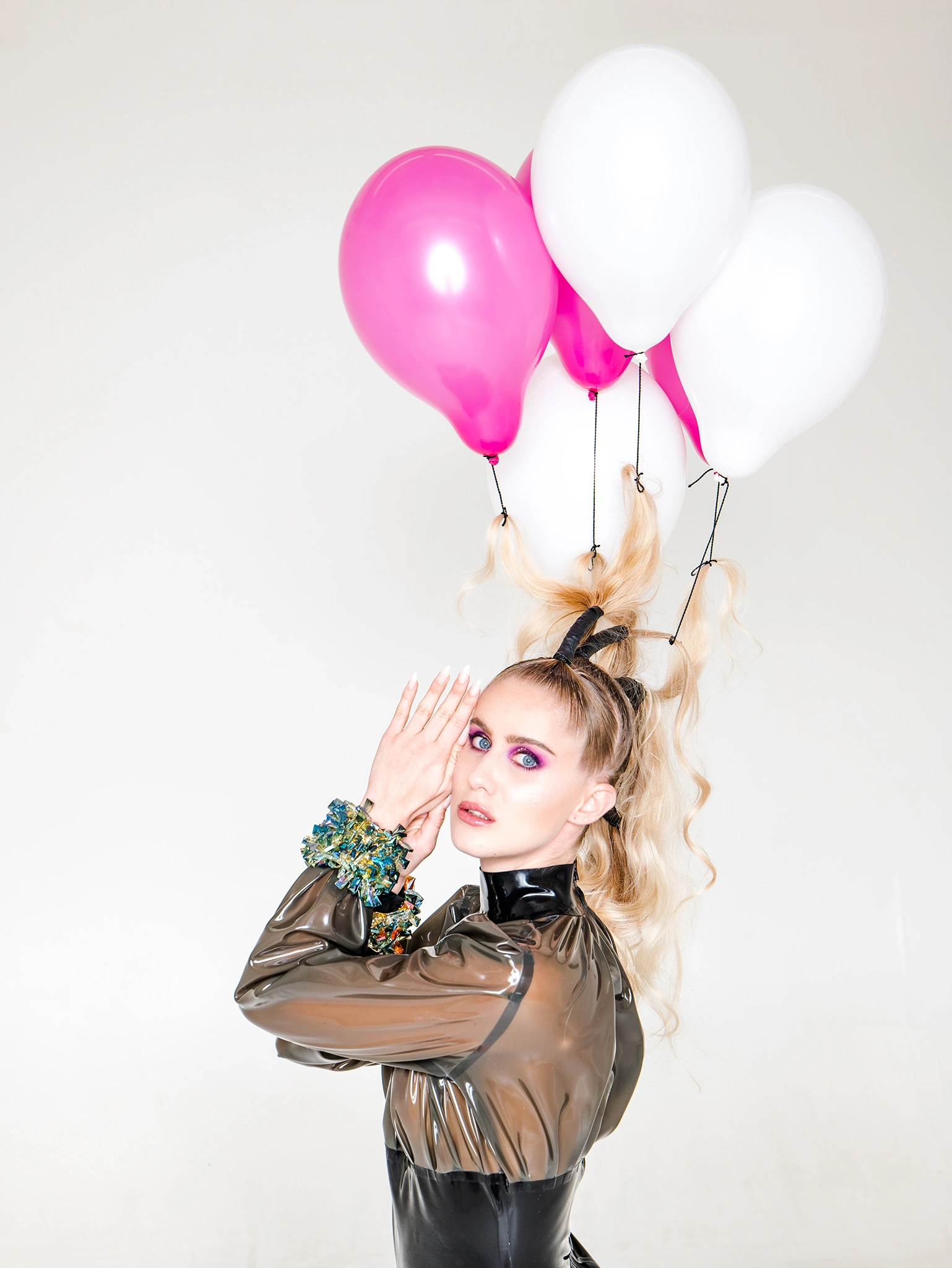 Editorial Look mit lila Make-up und Luftballons in den Haaren einer Frau. Make-up von Denise Drahtmueller