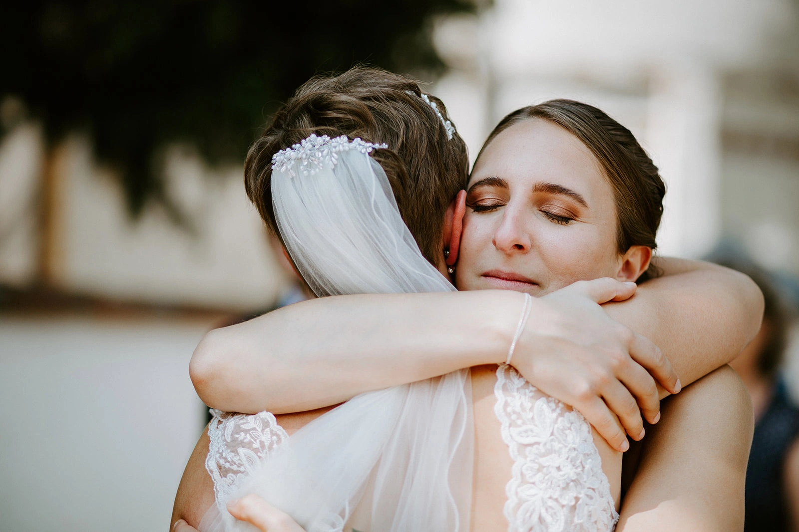 Braut umarmt ihre Trauzeugin, Haare und Make-up von Denise Drahtmueller