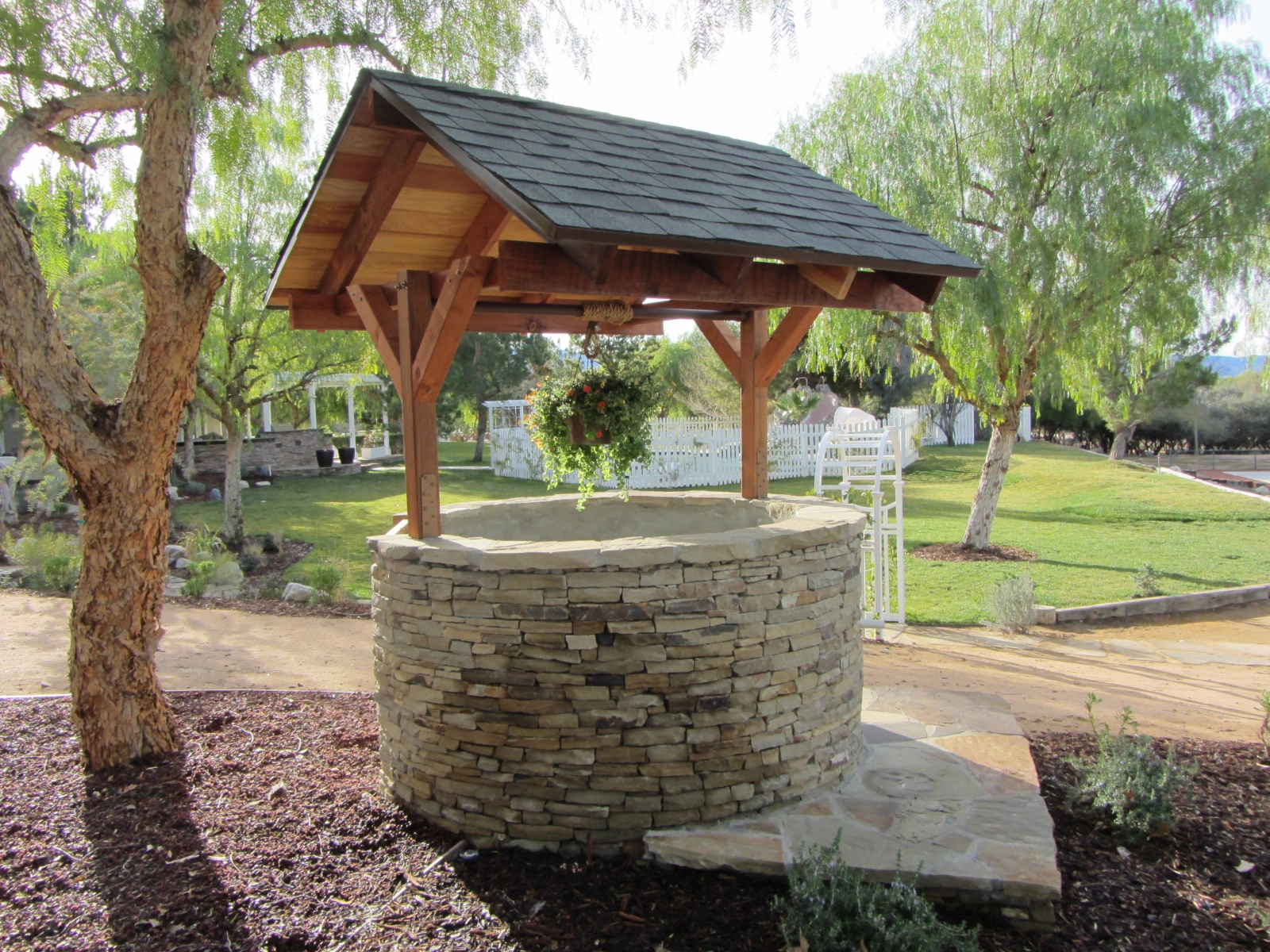 Convert a practical necessity into decor. This whimsical wishing well disguises a functional access area Build a wishing well