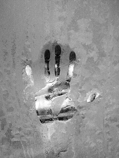 B&W silhouette of a hand in an icy glass