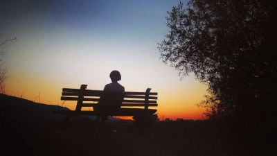 silhouette of a girl on a bench at sunset