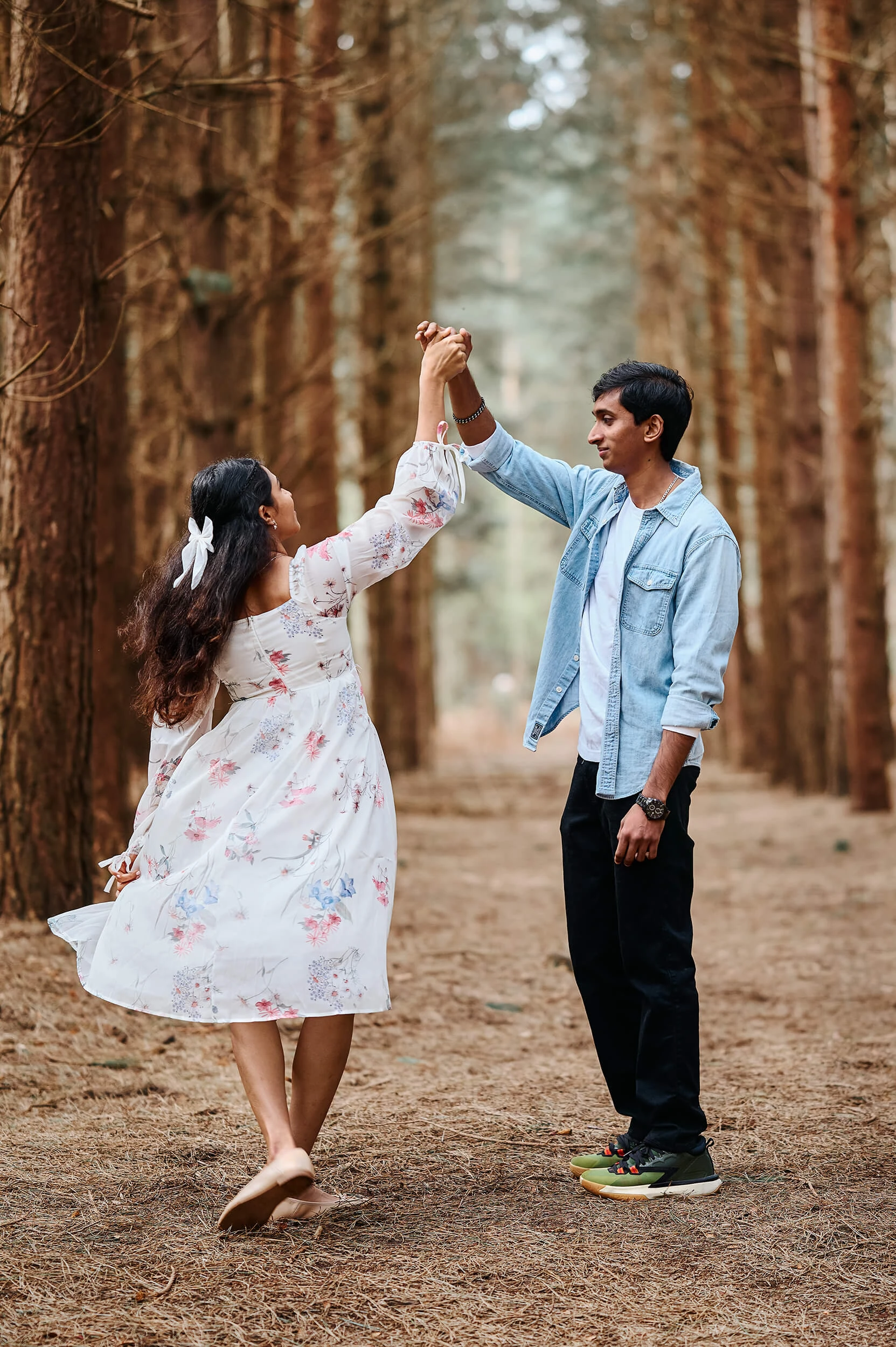 Couple dancing among tall trees during a natural photo session