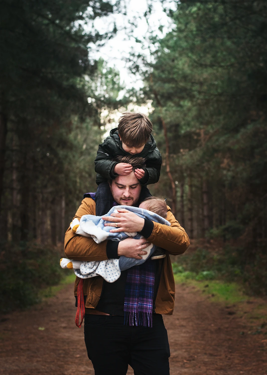 Dad giving piggy back and carrying baby in outdoor photography session