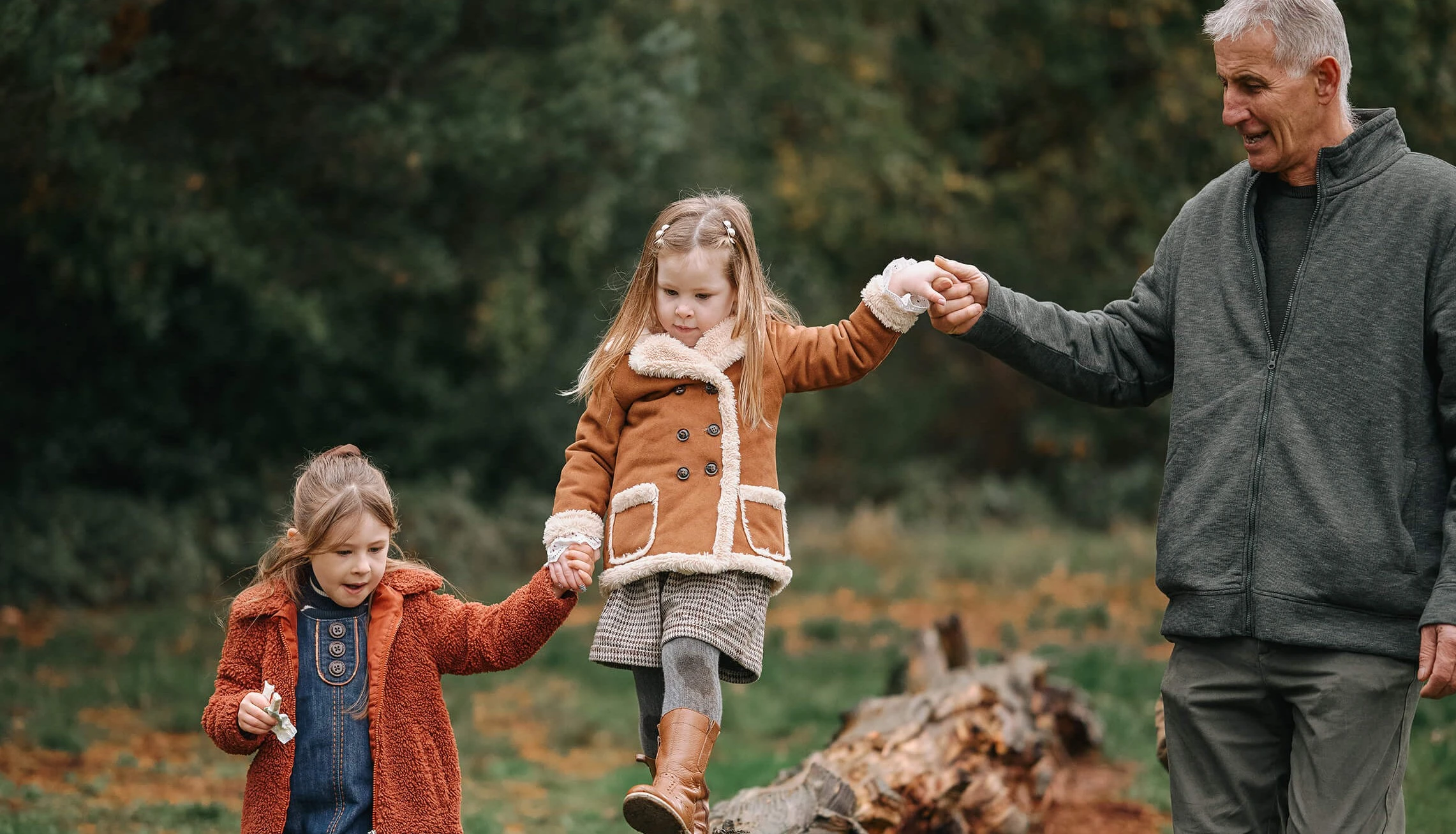 sisters and grandparent climbing trees in autumn photo session