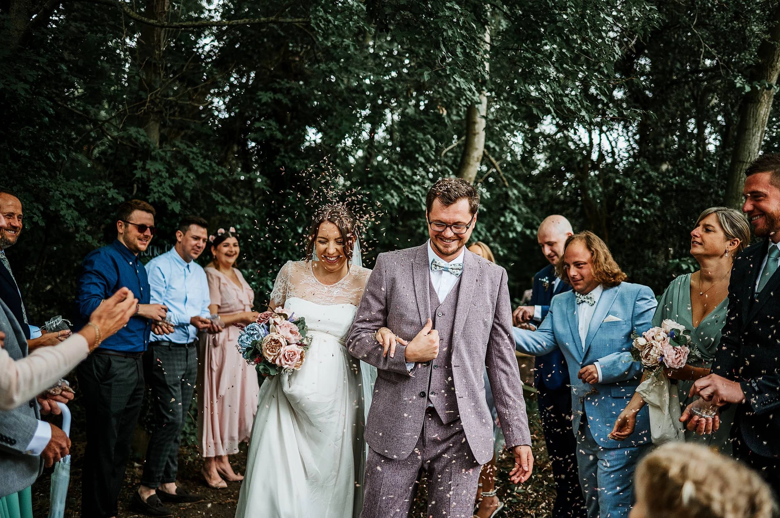 Couple in wedding attire at Upthorpe Woods near Bury St Edmunds for confetti photo