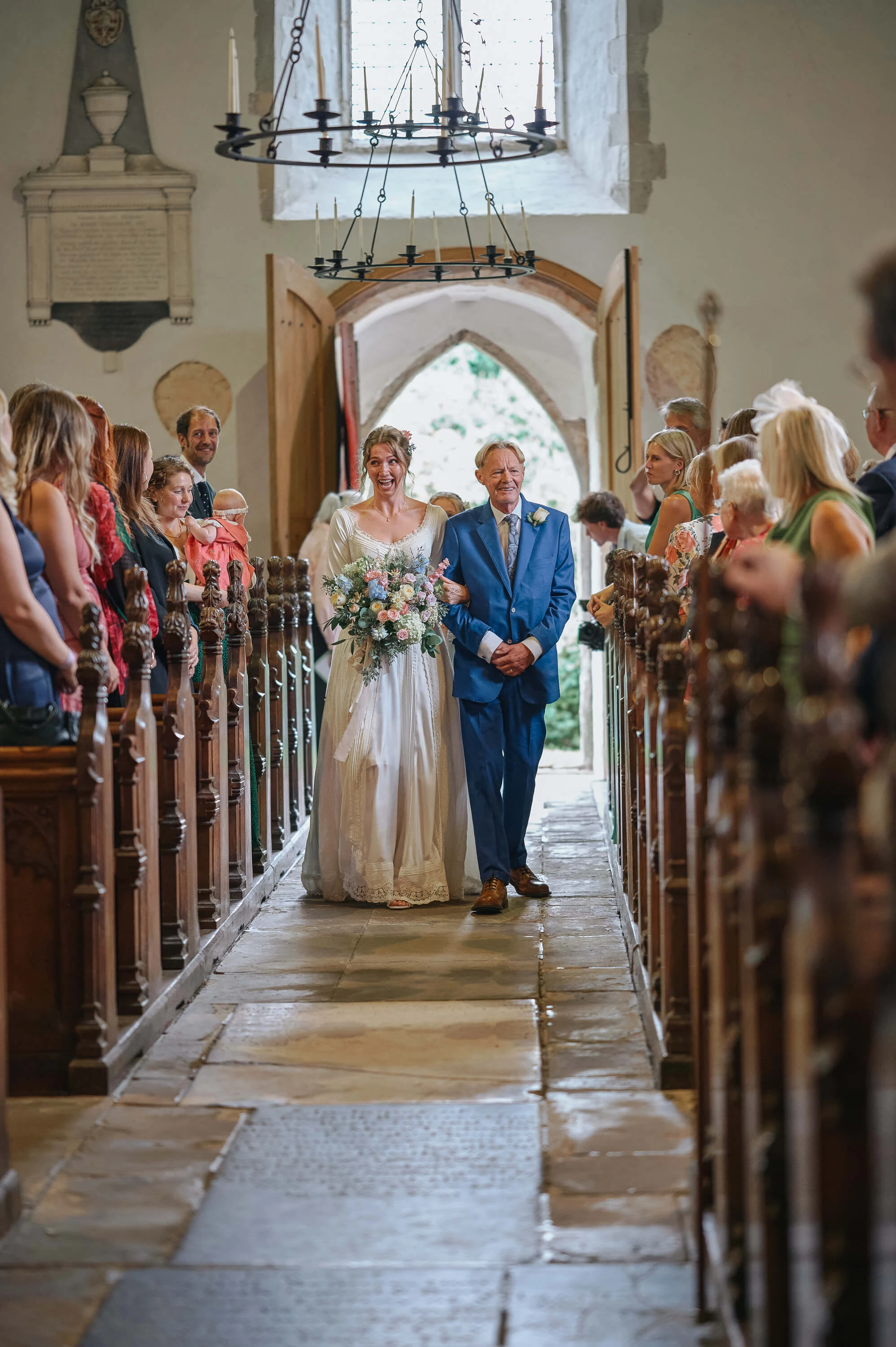 Annabelle walking down the aisle in Canterbury, with James waiting at the altar