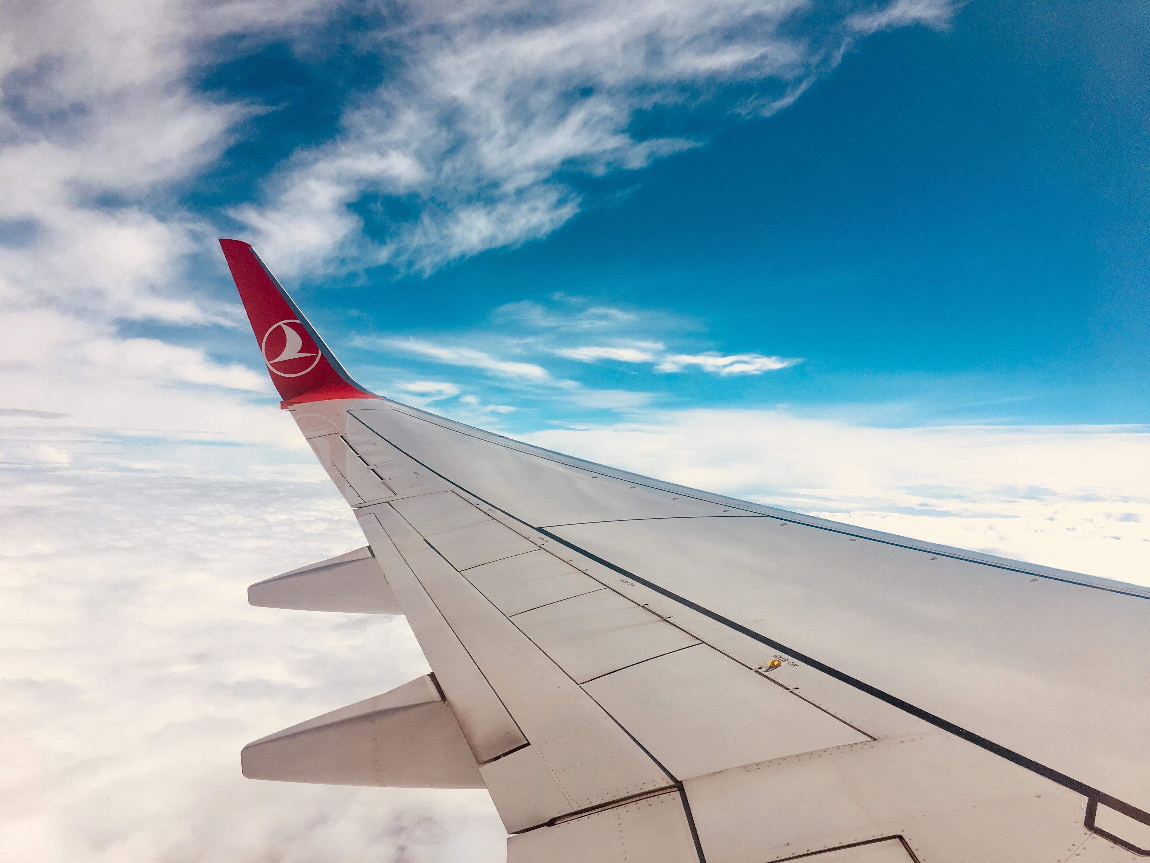 Commercial airplane wing in golden sunlight above Atlantic clouds on Europe transatlantic flight found through letsjourney.info independent travel deals platform 100+ providers