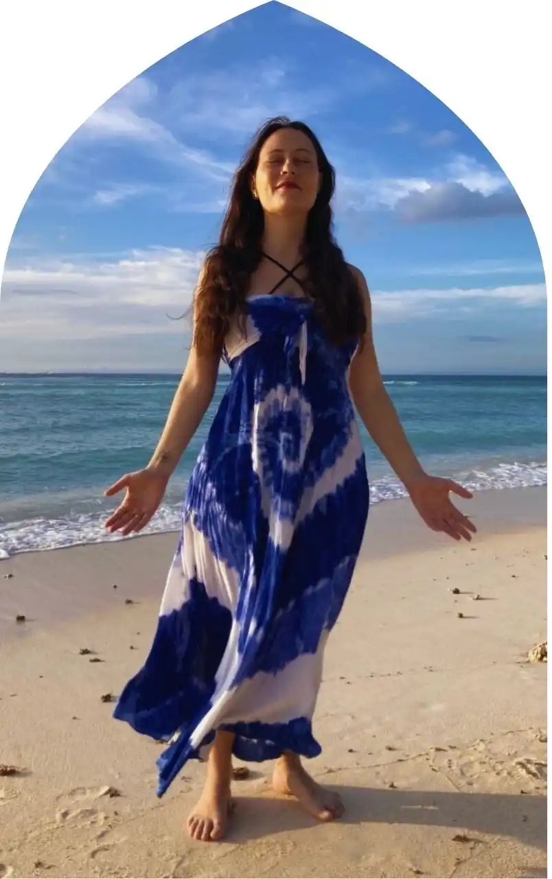 Carla on the beach in the Gili Islands with palms open in meditation Carla standing barefoot on a Gili Islands beach with palms open, embracing ocean energy and meditation