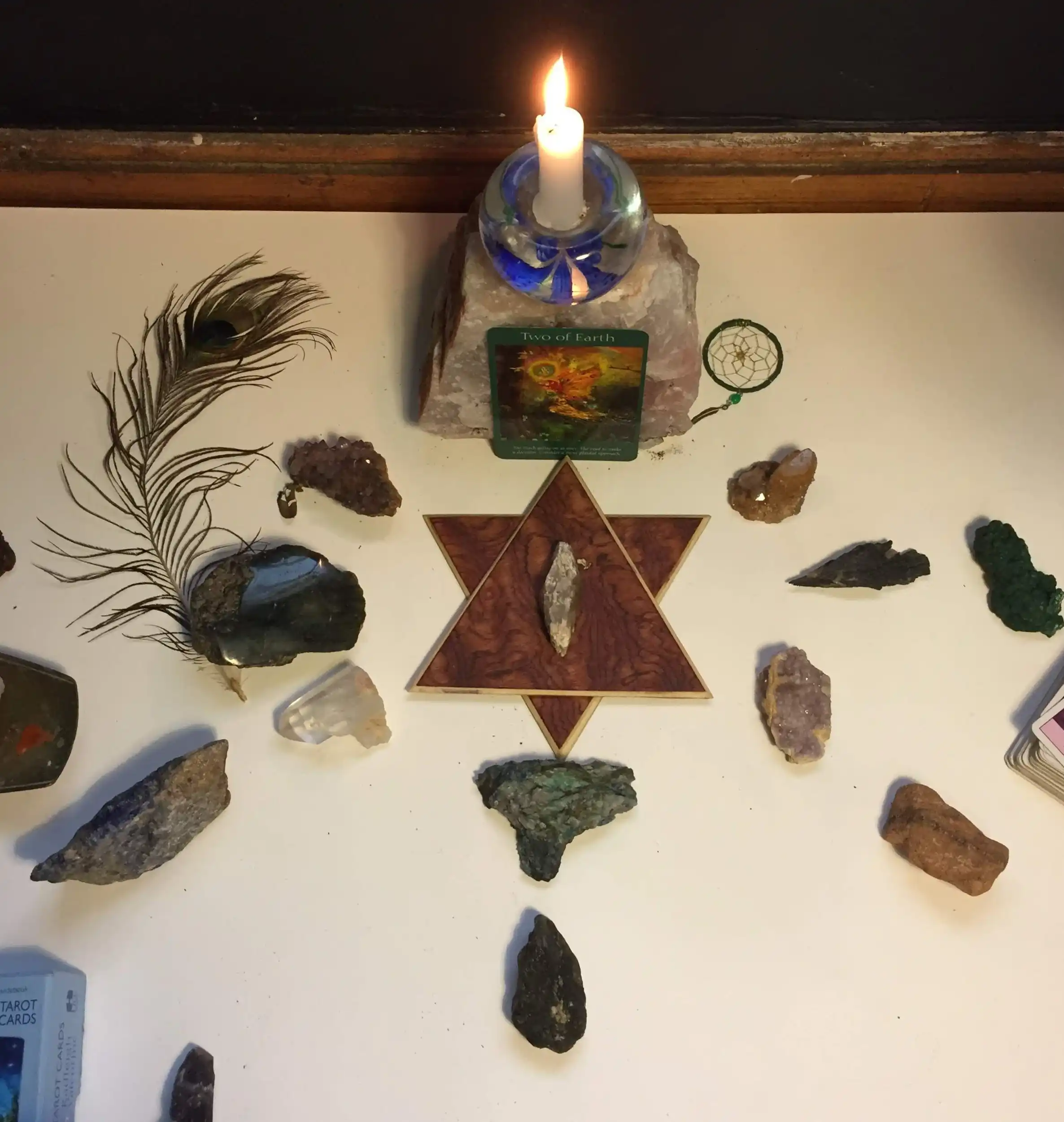 LunAscention crystal grid and altar for psychic readings and energy work. Sacred altar with candle, crystals, feather, and tarot card arranged for spiritual guidance and energy healing.