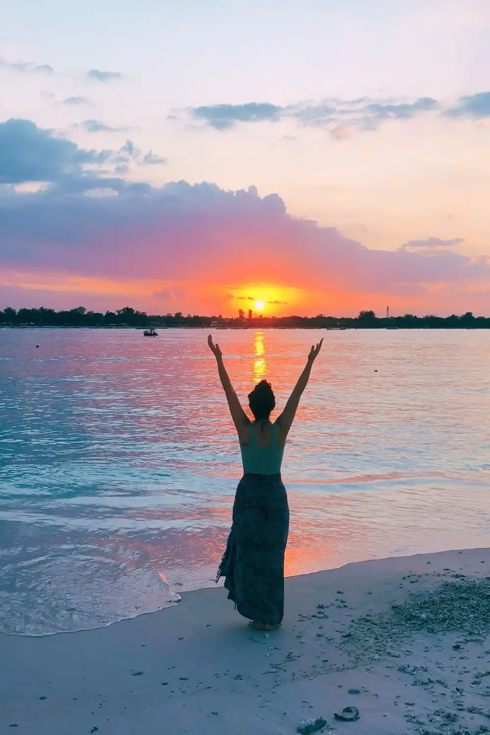 Psychic Carla raising arms to the sunset sky, symbolizing cosmic connection and astrology guidance