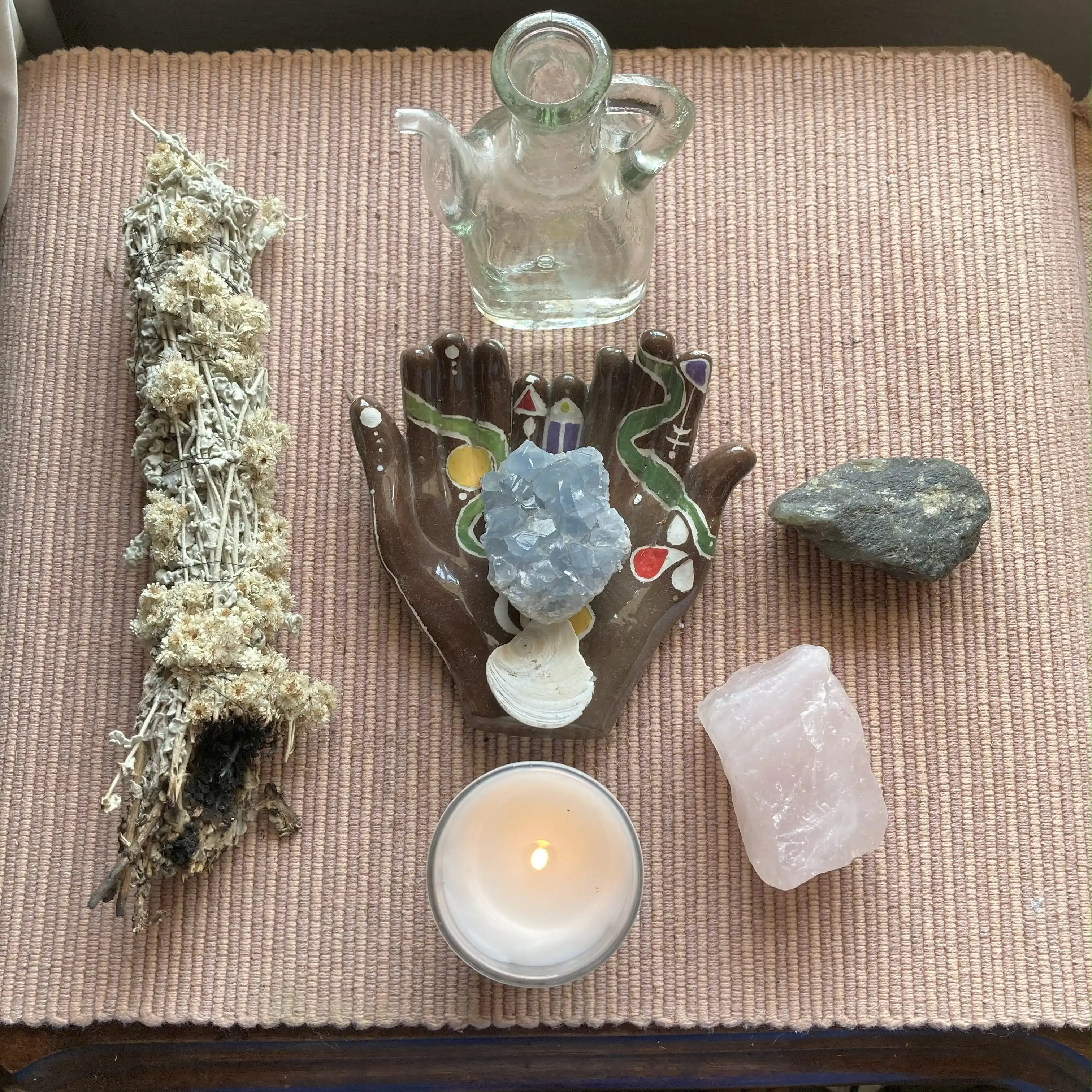 Sacred altar with candle, crystals, herbs, and ceremonial hand used in psychic readings and healing rituals by Carla at LunAscention.