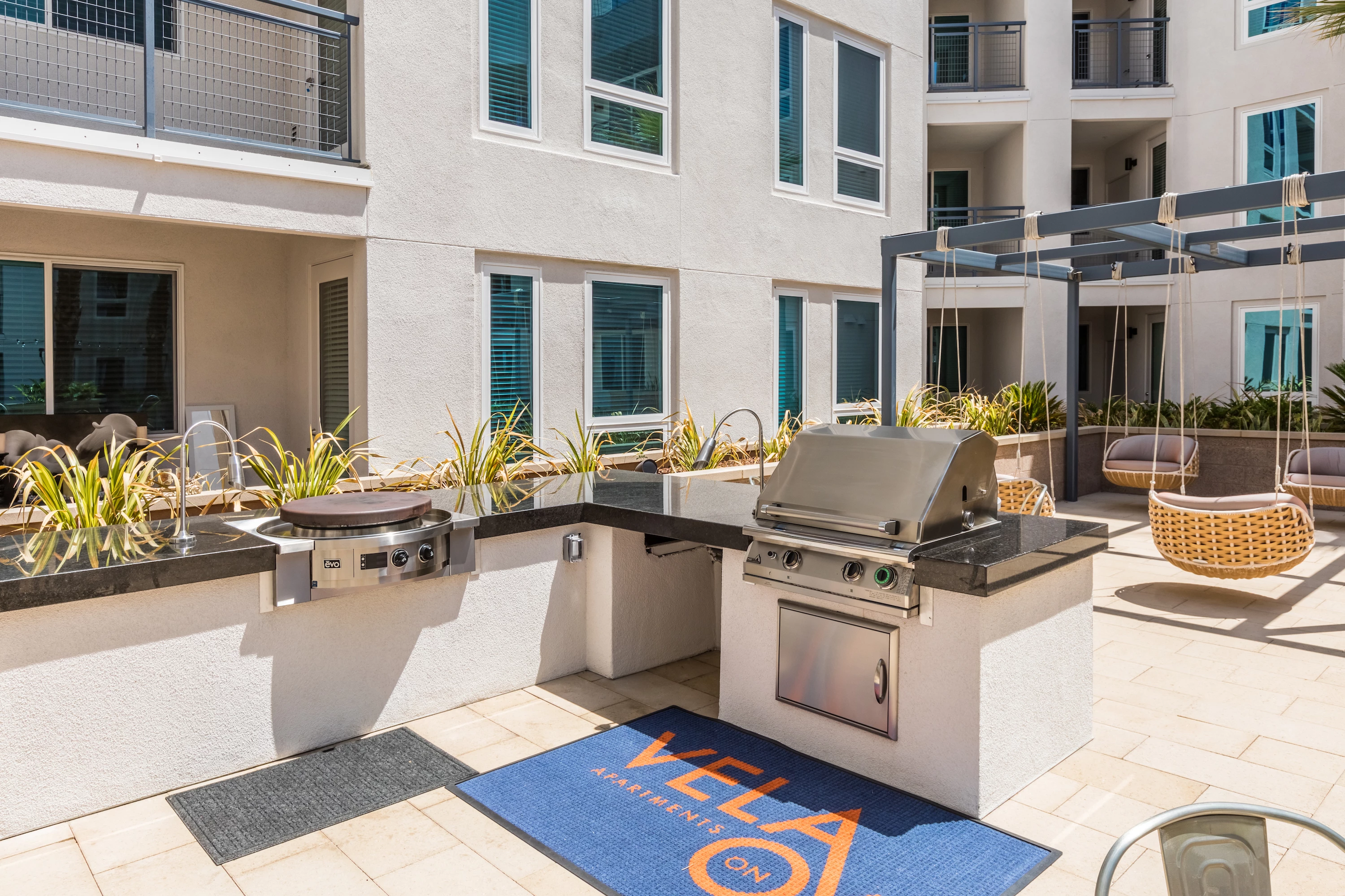 1241-12-exterior-courtyard-barbecue-and-evo-grill-at-vela-on-ox-apartments-in-woodlan.jpg