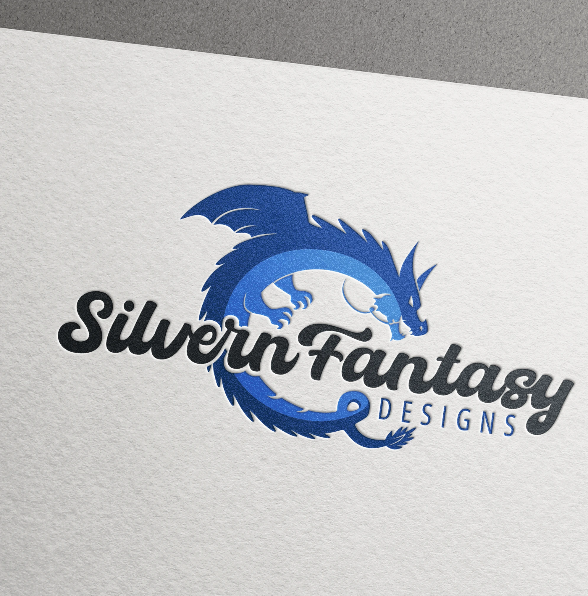 a blue dragon logo of Silvern Fantasy Designs company