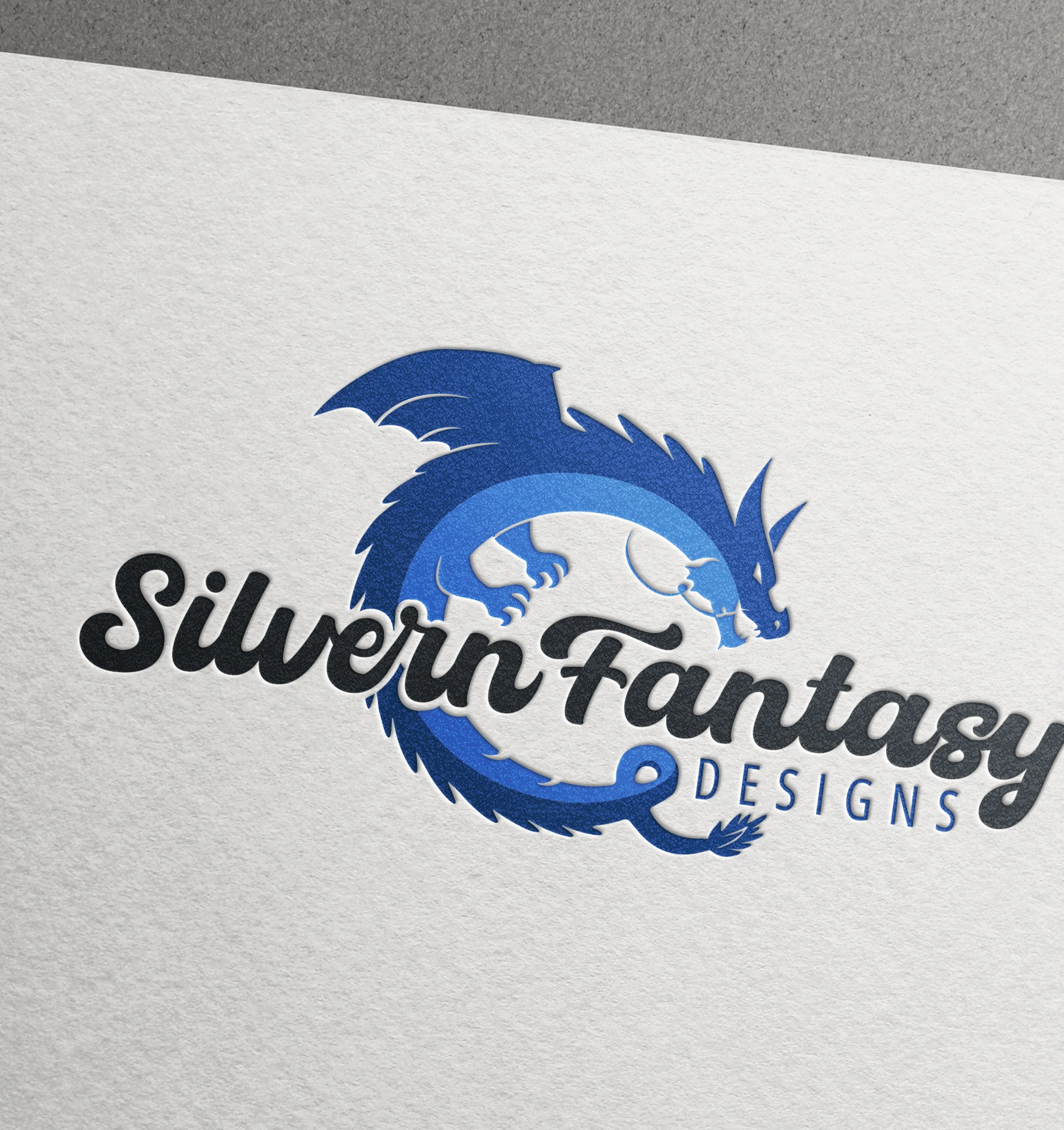 a blue dragon logo of Silvern Fantasy Designs company