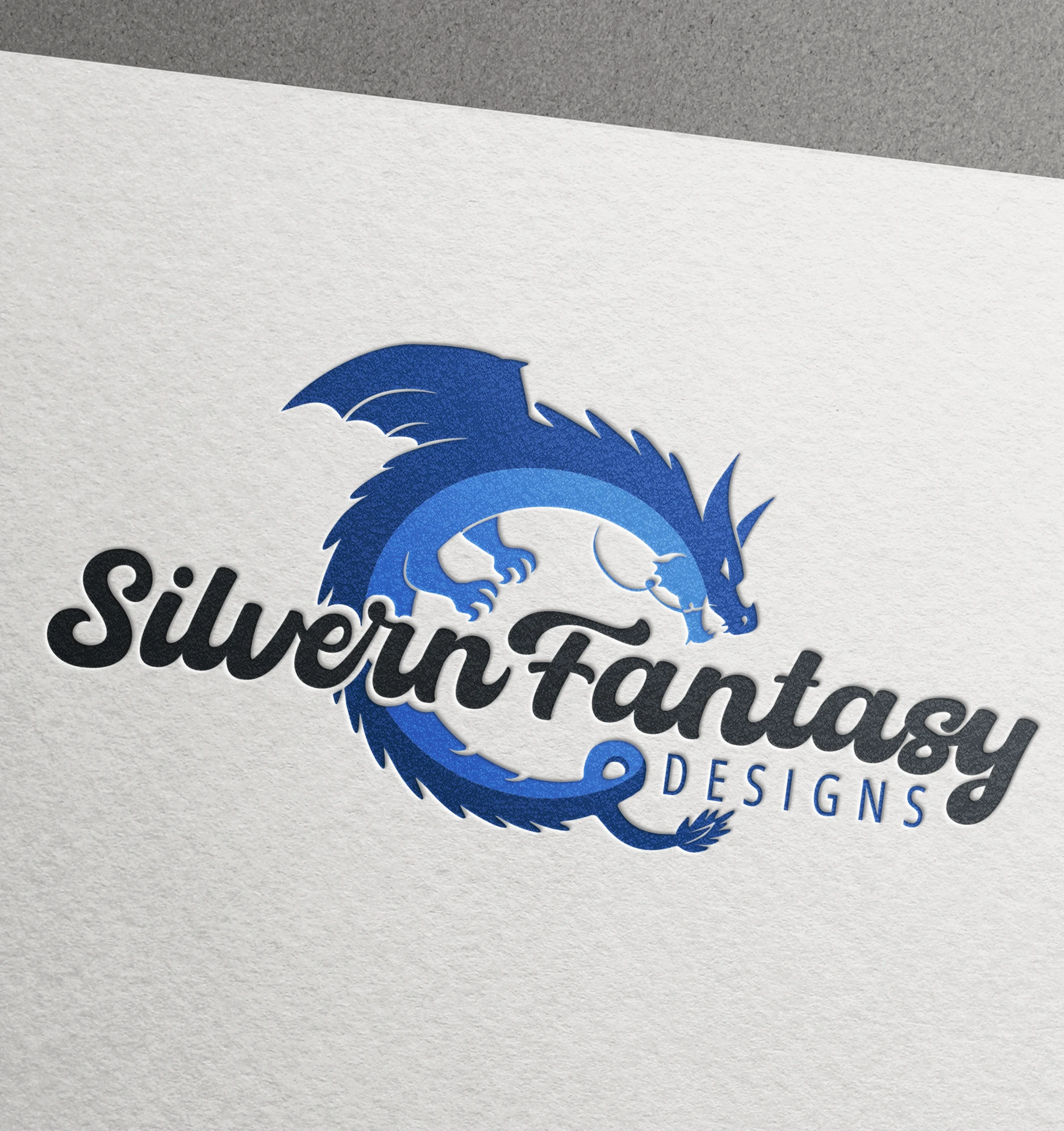 a blue dragon logo of Silvern Fantasy Designs company