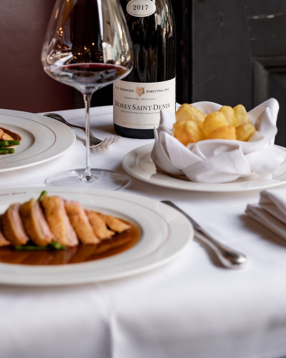 Versneden eendenfilet met saus en pommes soufflées