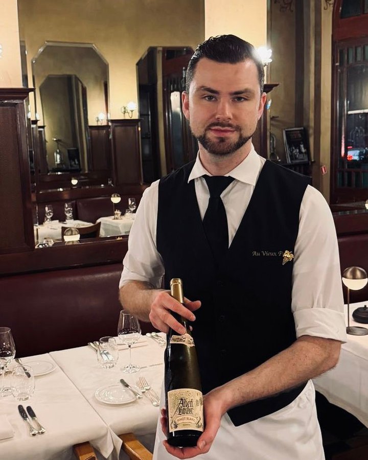 Sommelier Jens De Ridder met een fles wijn in de zaal van Au Vieux Port