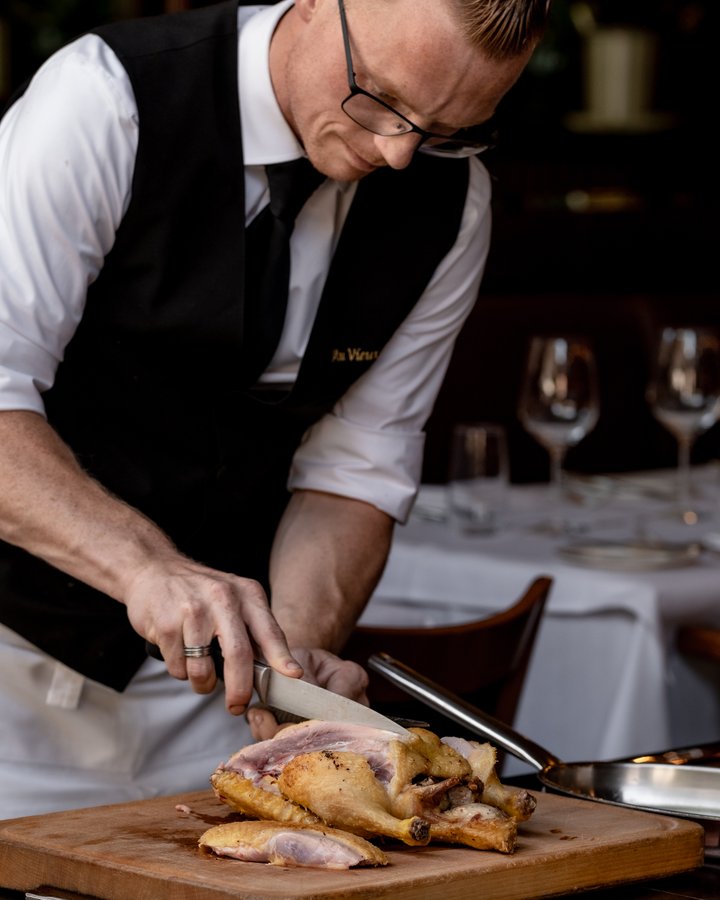 Maître Tom Schoonbaert versnijdt een kip aan de versnijtafel